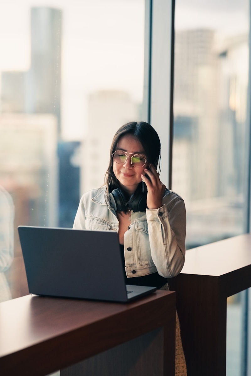 Woman talking on phone with laptop nearby
